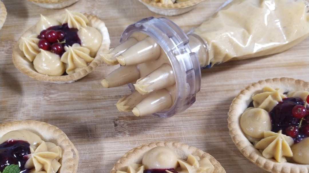 Photo de plusieurs tartelettes crémeux caramel et set Opale monté sur une poche à douille